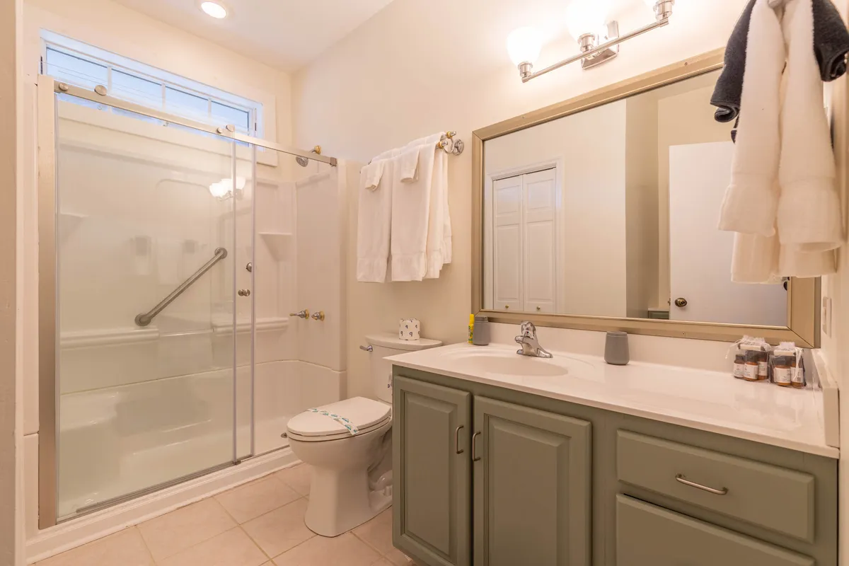 A modern, well-appointed bathroom featuring a spacious shower area, mirrored cabinet, and a sleek sink with ample countertop space. Plush towels are neatly arranged, and the overall design is clean and calming, inviting guests to refresh and unwind after a busy day.