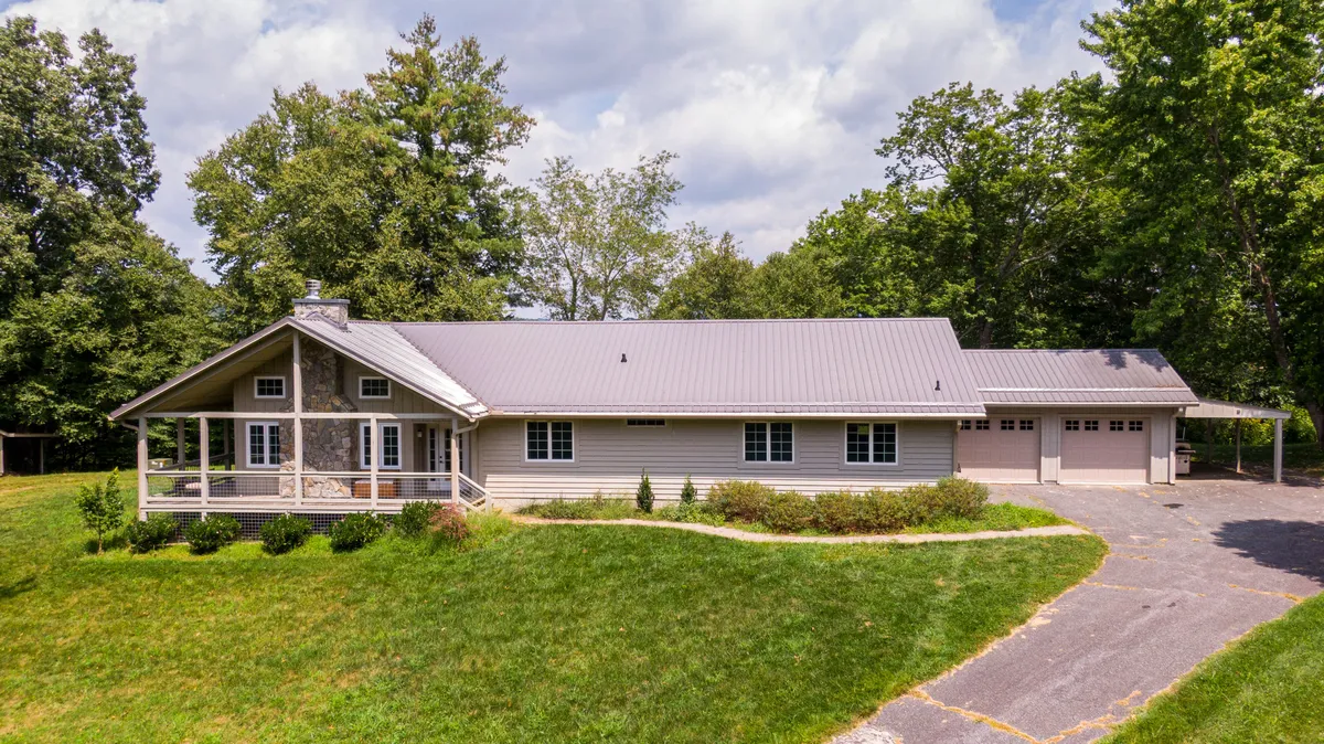 The front porch of the house features large windows, a landscaped garden, and a driveway. This space is clearly designed for family gatherings and outdoor play, with plenty of room for children to enjoy themselves and adults to relax while taking in the sunset.